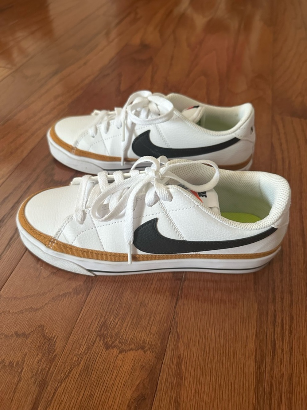 NikeWhite Skate Shoes with Black Swoosh and Gold Trim